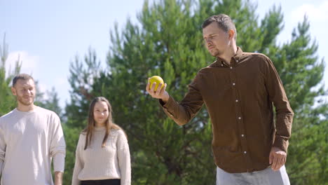 Close-up-view-of-caucasian-young-man-throwing-a-petanque-ball-on-the-beach-on-a-sunny-day