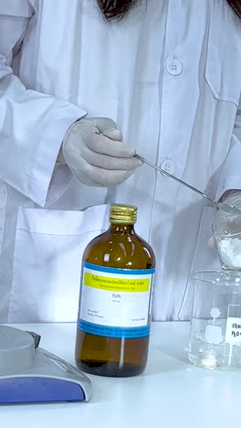 a scientist conducts an iodine clock reaction using vitamin c and starch, demonstrating chemical changes in a lab setting