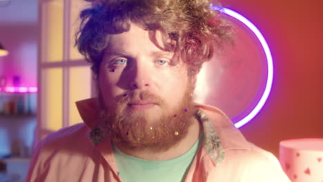 man with colorful glitter beard and hair in neon lights