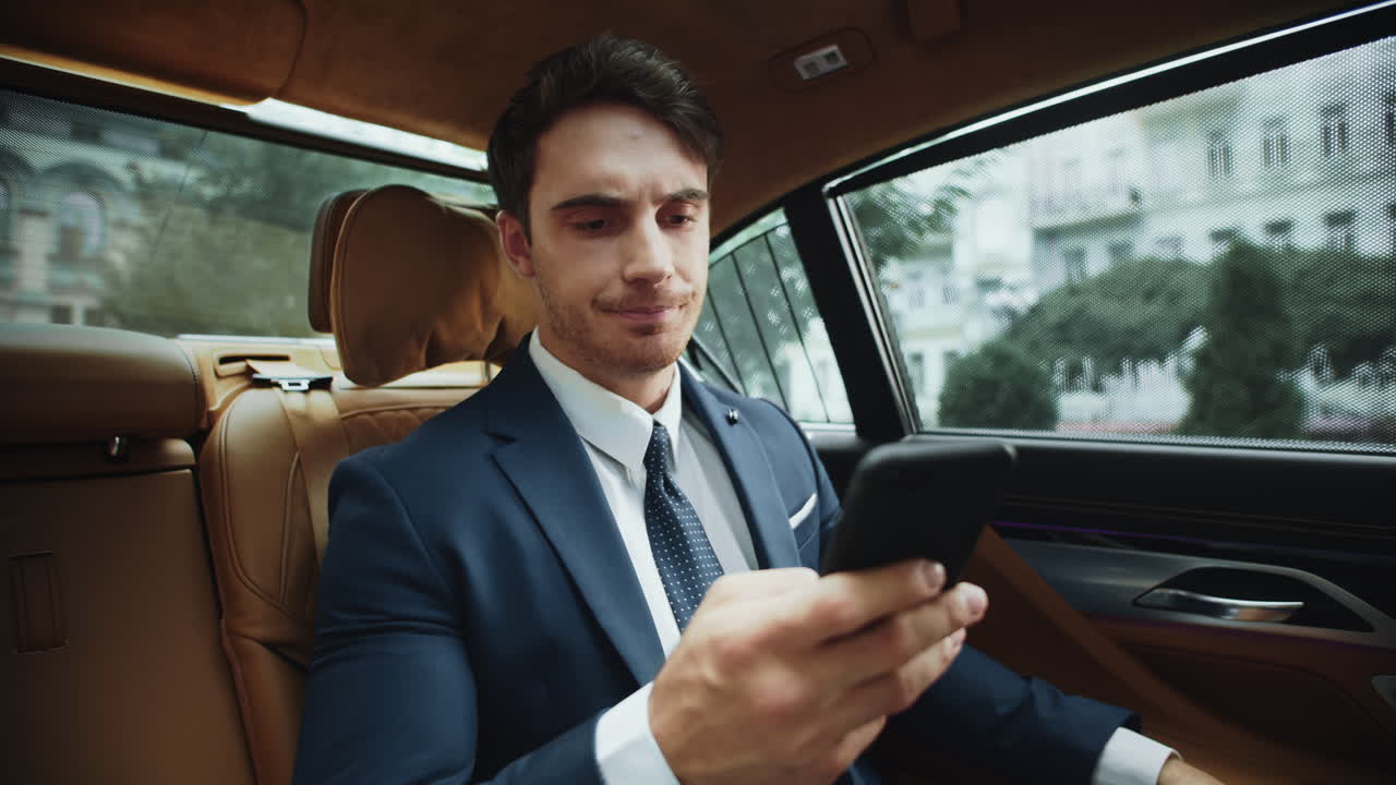 hombre profesional molesto leyendo malas noticias en el teléfono inteligente en el salón de coches de negocios.