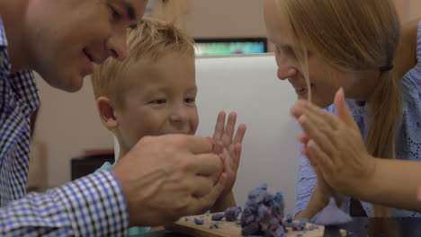 parents and child playing with plasticine