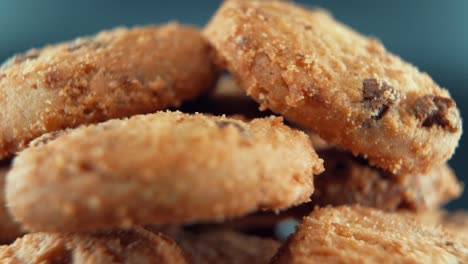 a macro close up cinematic shot of a plate full of crispy chocolate chip cookies, on a 360 rotating stand, professional studio lighting, super slow motion, 120 fps, full hd video