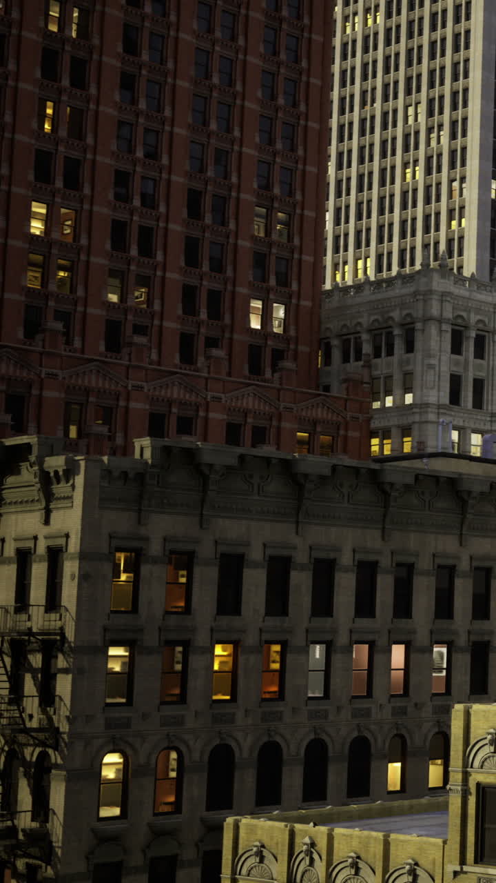 Edifici in città di notte con luci che brillano dalle finestre