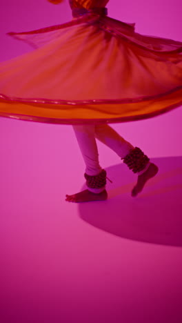 vertical video close up of feet with bells of female kathak dancer performing dance wearing traditional indian dress against purple background 1