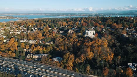 panoramic aerial establishing view of cathedral on hilltop overlooking seattle washington highway at midday