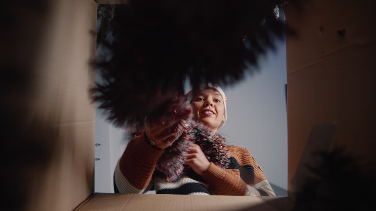 mujer festiva sacando adornos de navidad de la caja