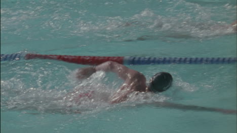 a group of swimmers race to the other side of the pool