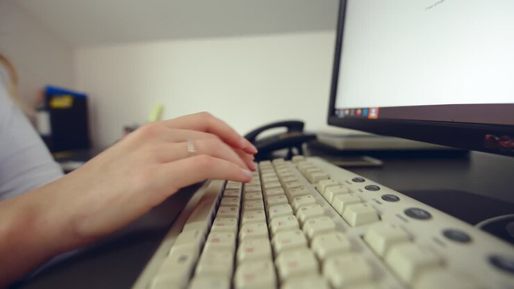 CHISINAU, MOLDOVA - NOVEMBER, 2021: Woman working on computer at the office with Dell monitor and logitech keyboard