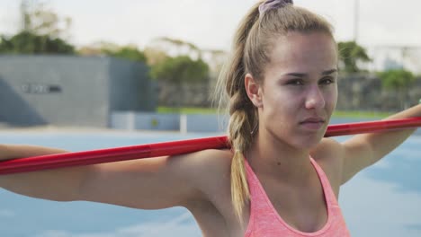 vista lateral de una atleta caucásica con una jabalina en los brazos