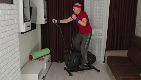 Active-healthy-senior-old-mature-man-in-sportswear-using-orbitrek,-training-cardio-workout-at-home