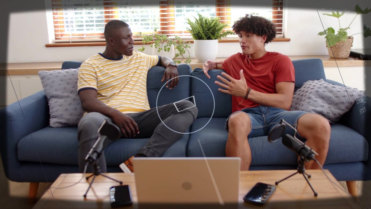 Starting recording, co-hosts in red, yellow striped tees gesturing on blue sofa with laptop mics