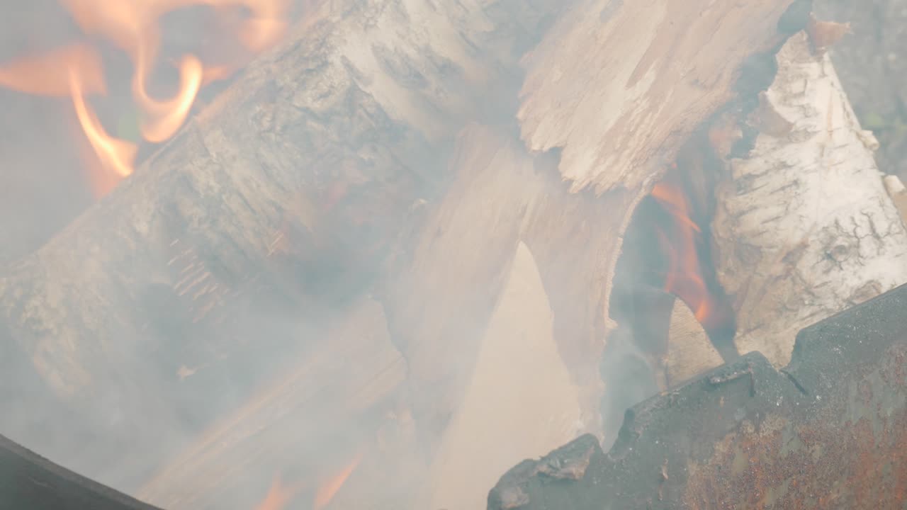 llamas anaranjadas suaves de la quema de troncos de abedul en la chimenea al aire libre