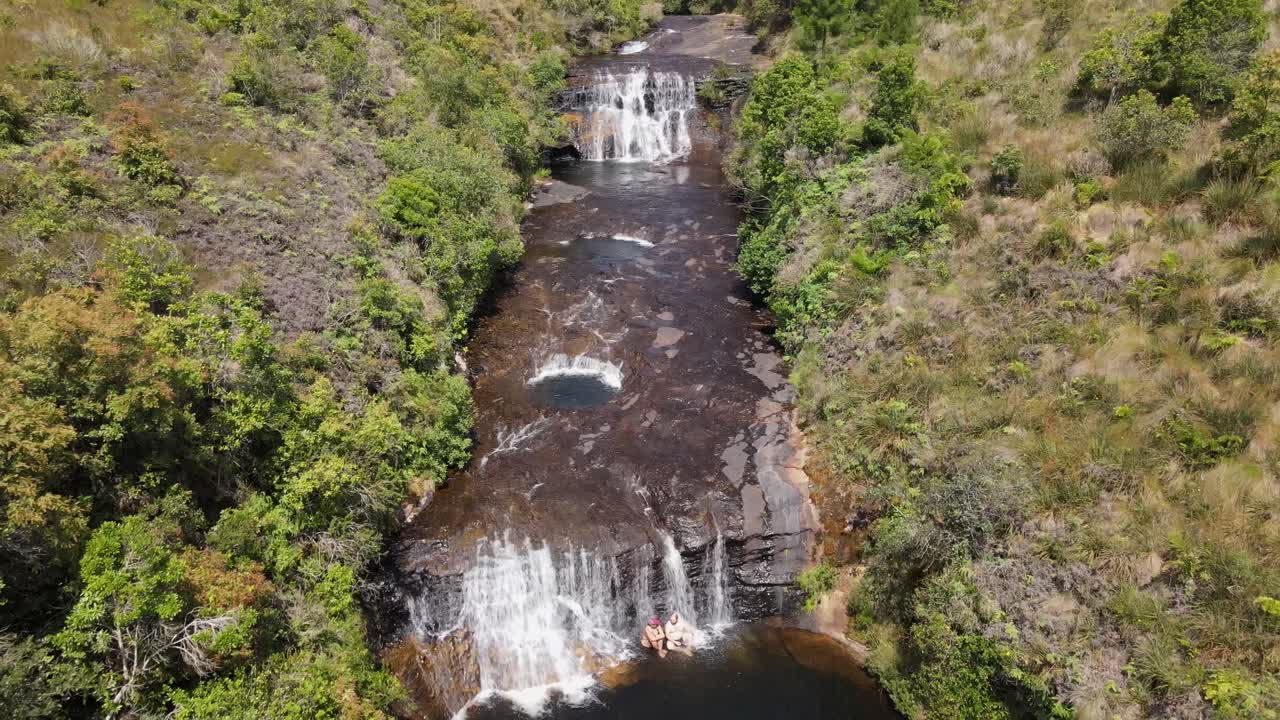 gente refrescándose en la cascada, vista de drones