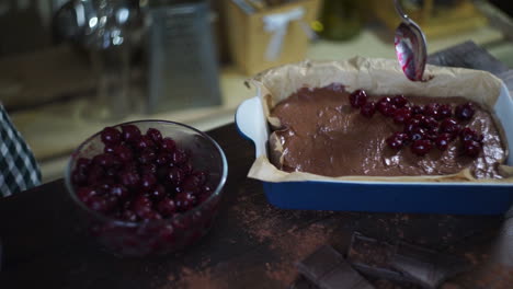 man hands adding cherry to chocolate dough. cooking chocolate cake. brownie