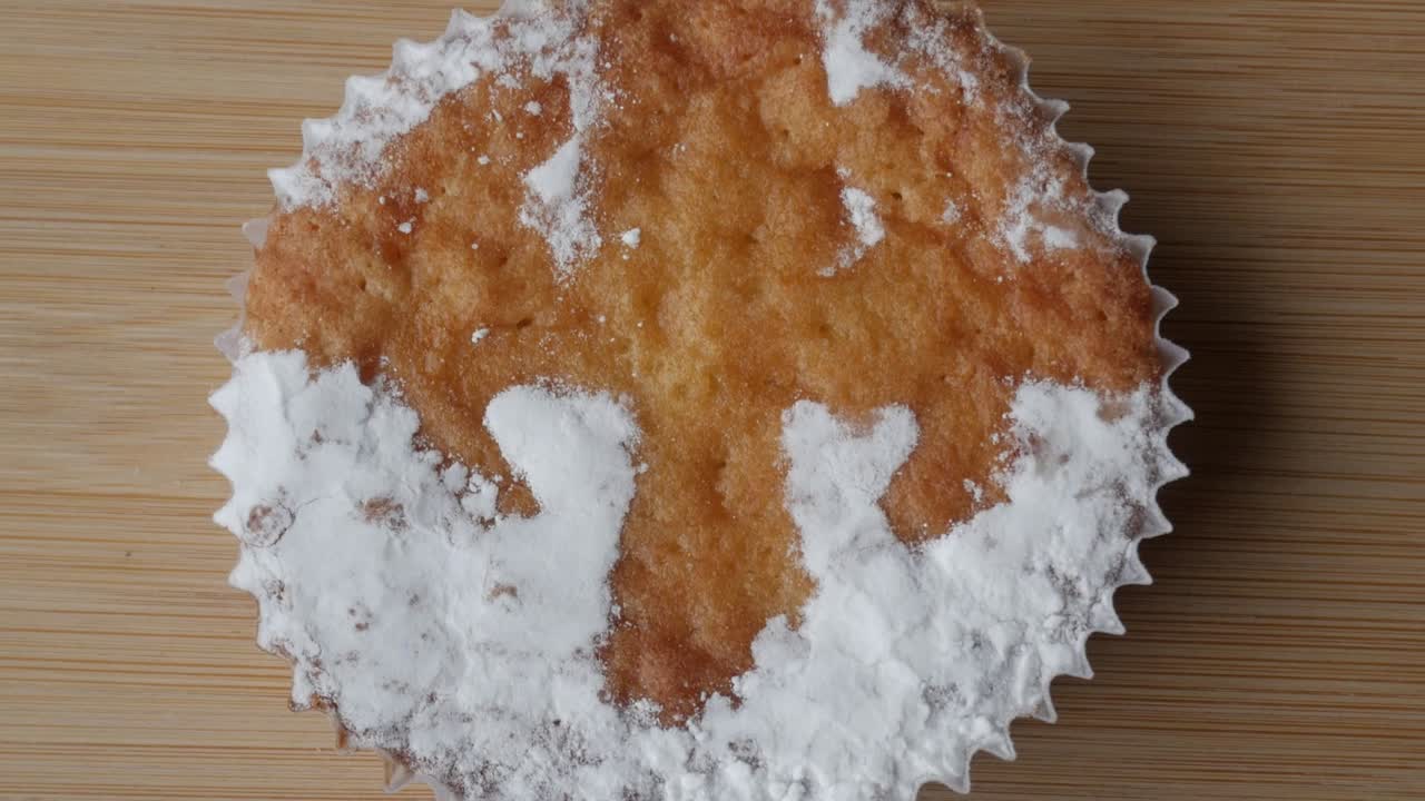 Torta di Santiago tradizionale con decorazione di zucchero a velo su tagliere di legno.