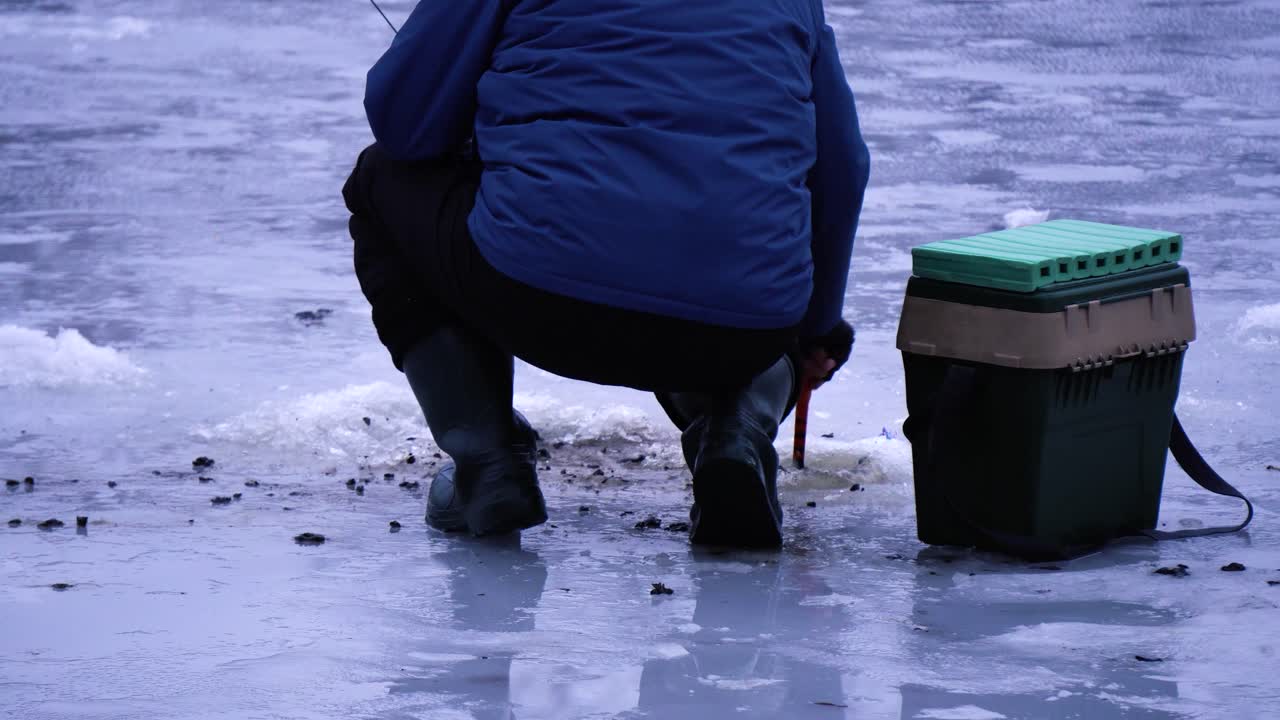 tiro medio del pescador quita la cuchara del agujero nieve y hielo extra para la pesca de invierno