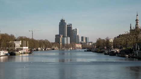 timelapse video of the amstel river leading in to amsterdam. in the distance, the amstel towers and amstel district can be seen.