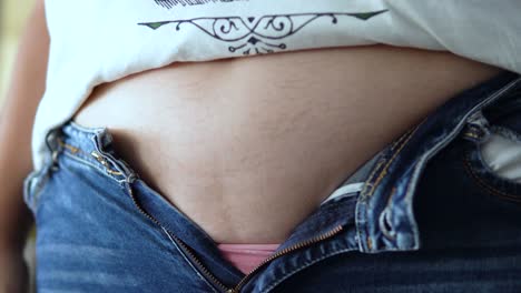 Jeans don&#039;t fit, Trying to wear trousers, close up 4K shot