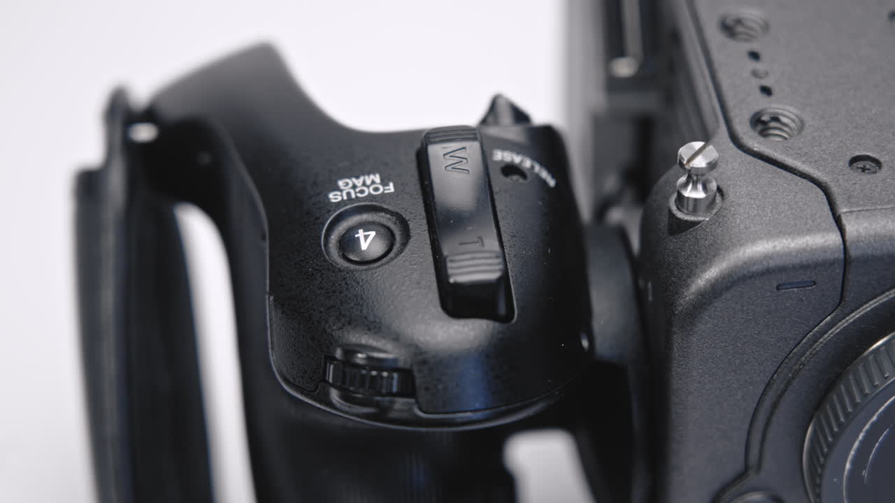 black, firm, plastic film camera handle with zoom and function buttons