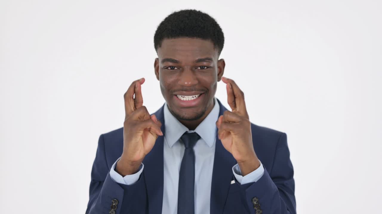 joven orando con los dedos cruzados sobre un fondo blanco