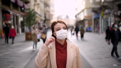 hermosa chica con máscara médica protectora y ropa de moda se encuentra en la calle