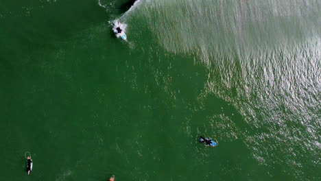 Vista-Superior-De-La-Playa-Turquesa-Con-Varios-Surfistas-Disfrutando-De-Las-Olas-Espumosas-En-San-Francisco,-California,-Ee.uu.