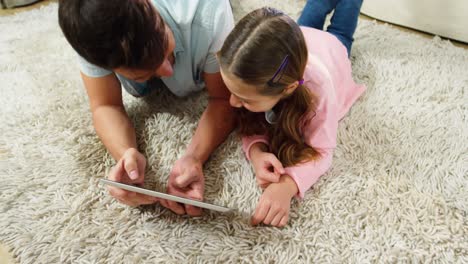 padre e hija usando una tableta digital en la sala de estar