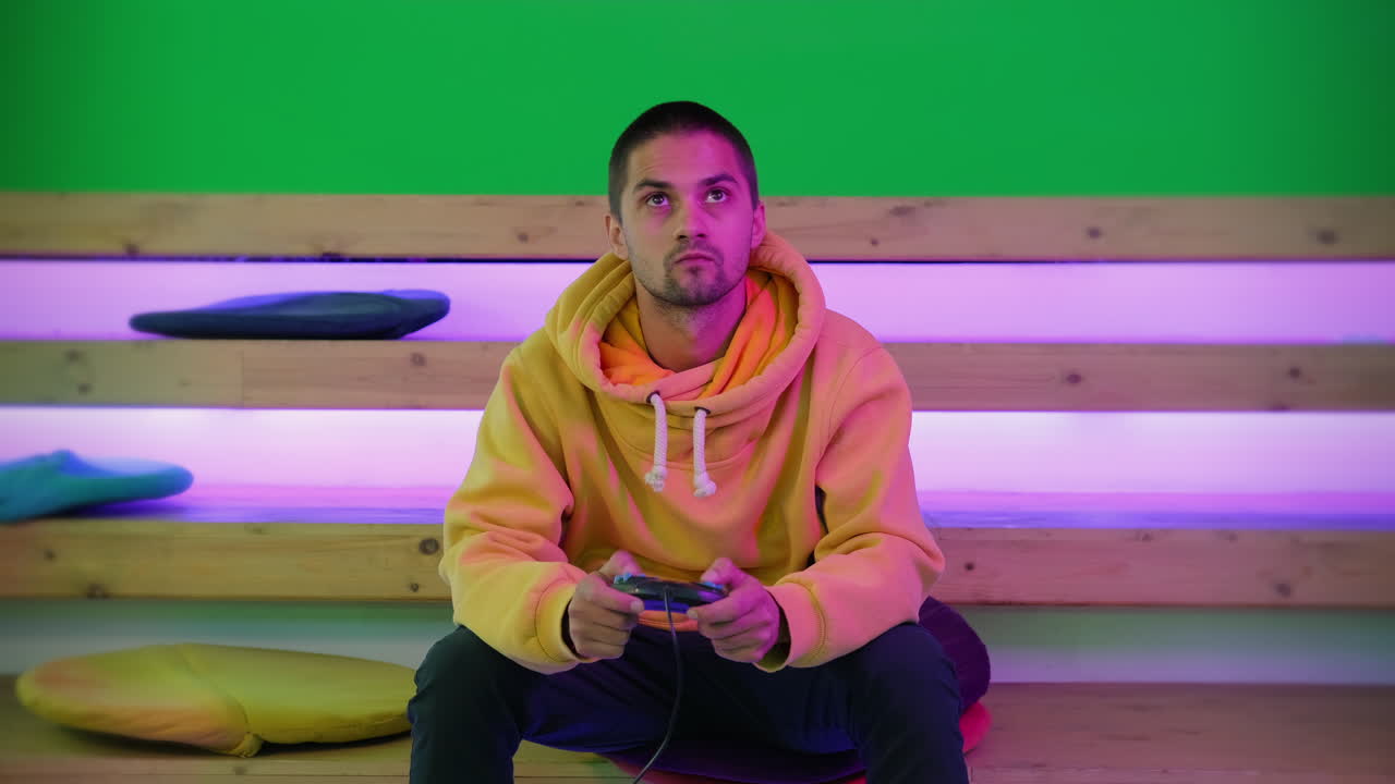 Man playing video games in a brightly lit room