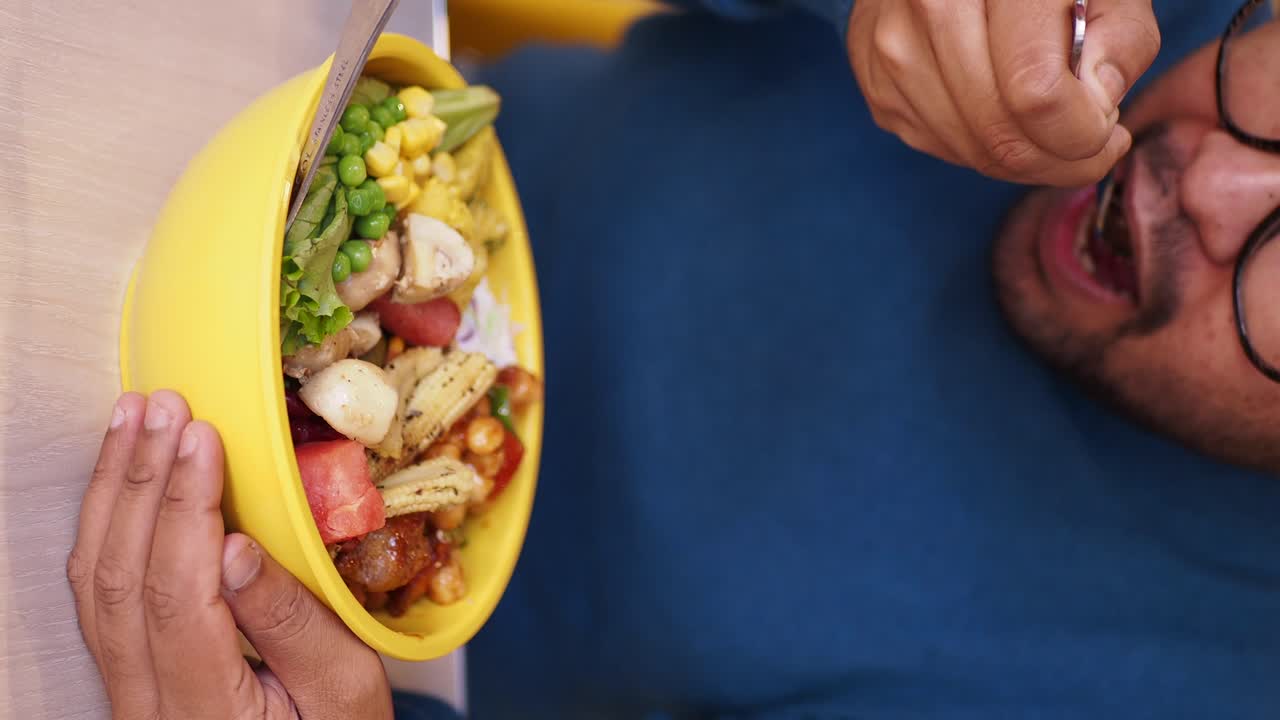 Person eating a healthy mixed salad bowl