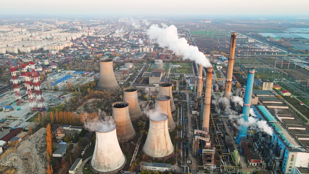 Power station with a lot of tubes and facilities in Bucharest at sunset, a lot of foam. Cityscape, view from the drone, Romania