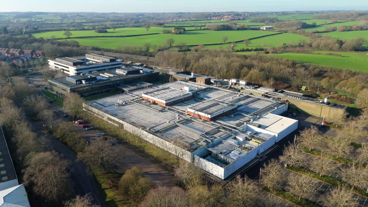 Aerial drone glide over a large-scale data storage facility highlighting the expansive rooftop cooling network in Royal Leamington Spa