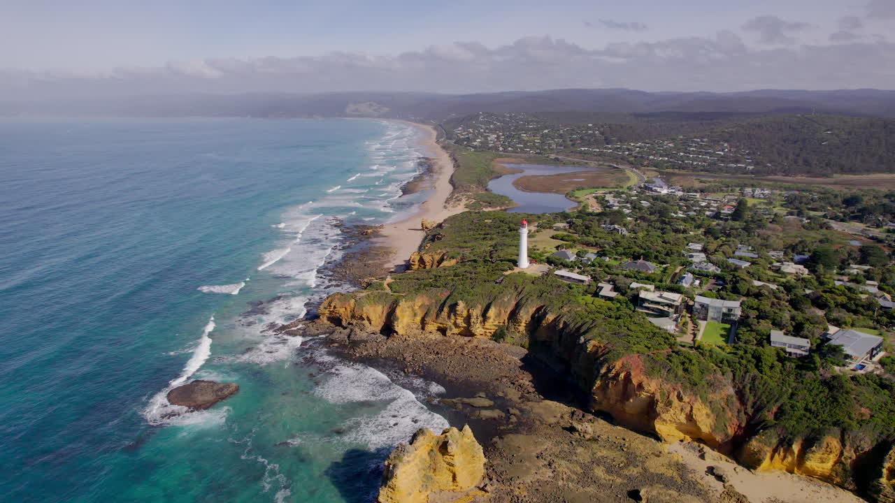 Cinematic aerial drone shot of Split Point Lighthouse and rugged coastline in Victoria, Australia. Captures ocean waves, cliffs, and scenic coastal views for travel, adventure, and tourism projects