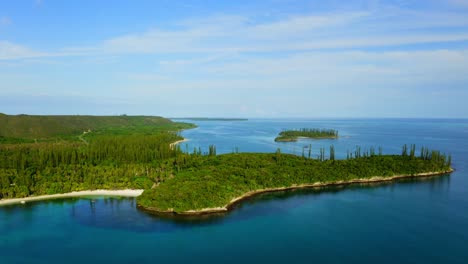 Drone-shot-moving-forward-toward-a-tropical-coast-with-some-little-islands-and-beaches-during-a-beautiful-day