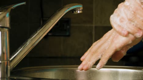 Washing-hands-with-soap-in-a-home-kitchen-sink-Slow-motion