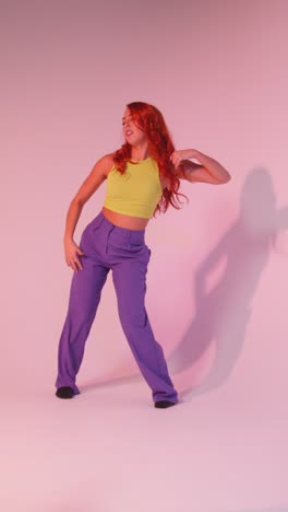 Full-Length-Vertical-Video-Studio-Shot-Of-Woman-Dancing-Against-Pink-Background