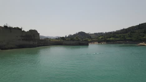 Pedal-boat-ride-along-the-steep-cliffs-of-the-islands-coast-on-the-Ionian-Sea,-Sidari,-Corfu,-Greece,-aerial