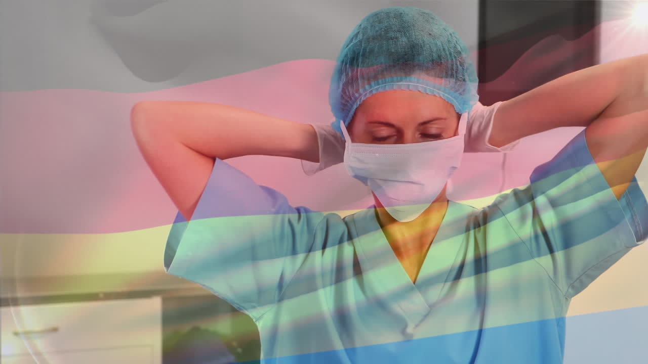 Animation of flag of germany waving over female surgeon in operating theatre