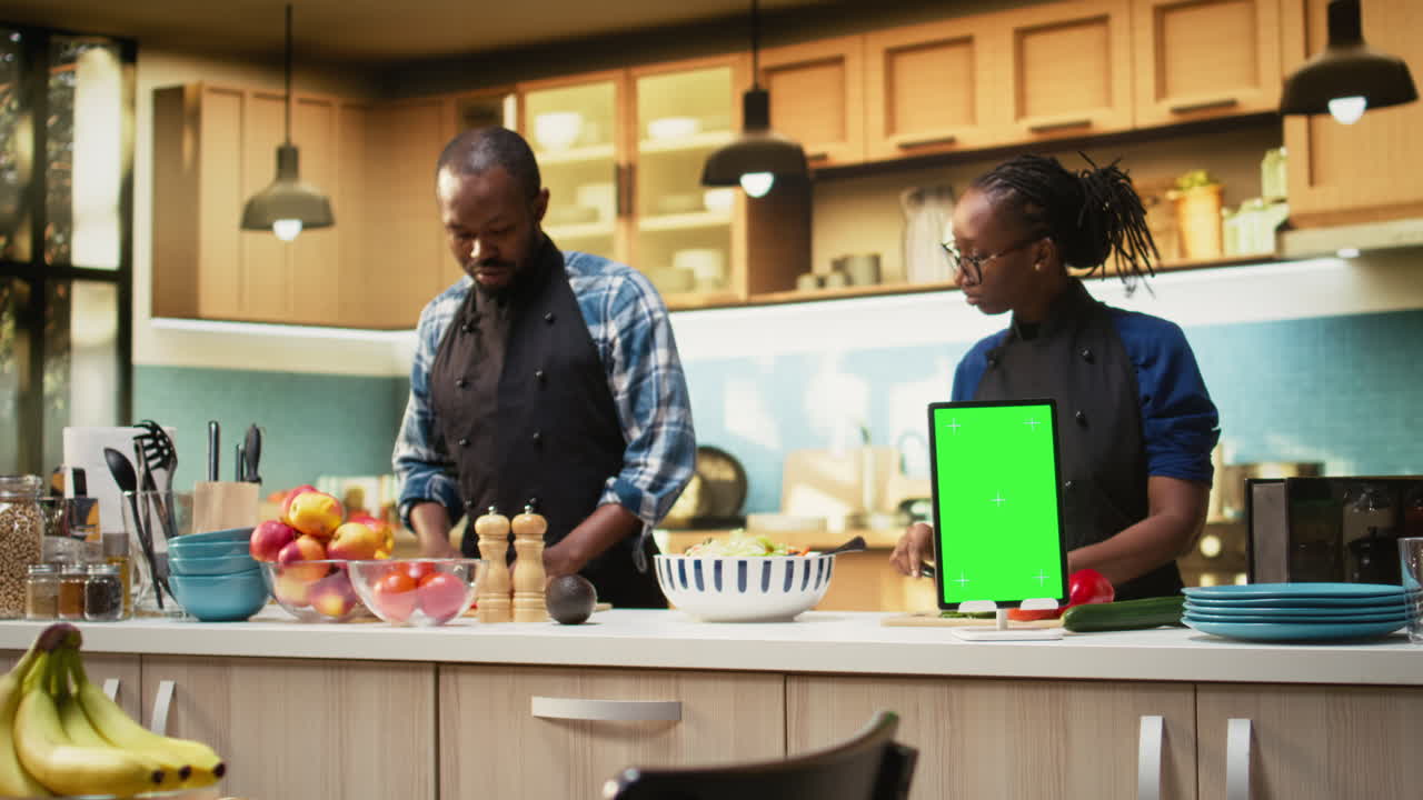 People cooking in the kitchen using a tablet