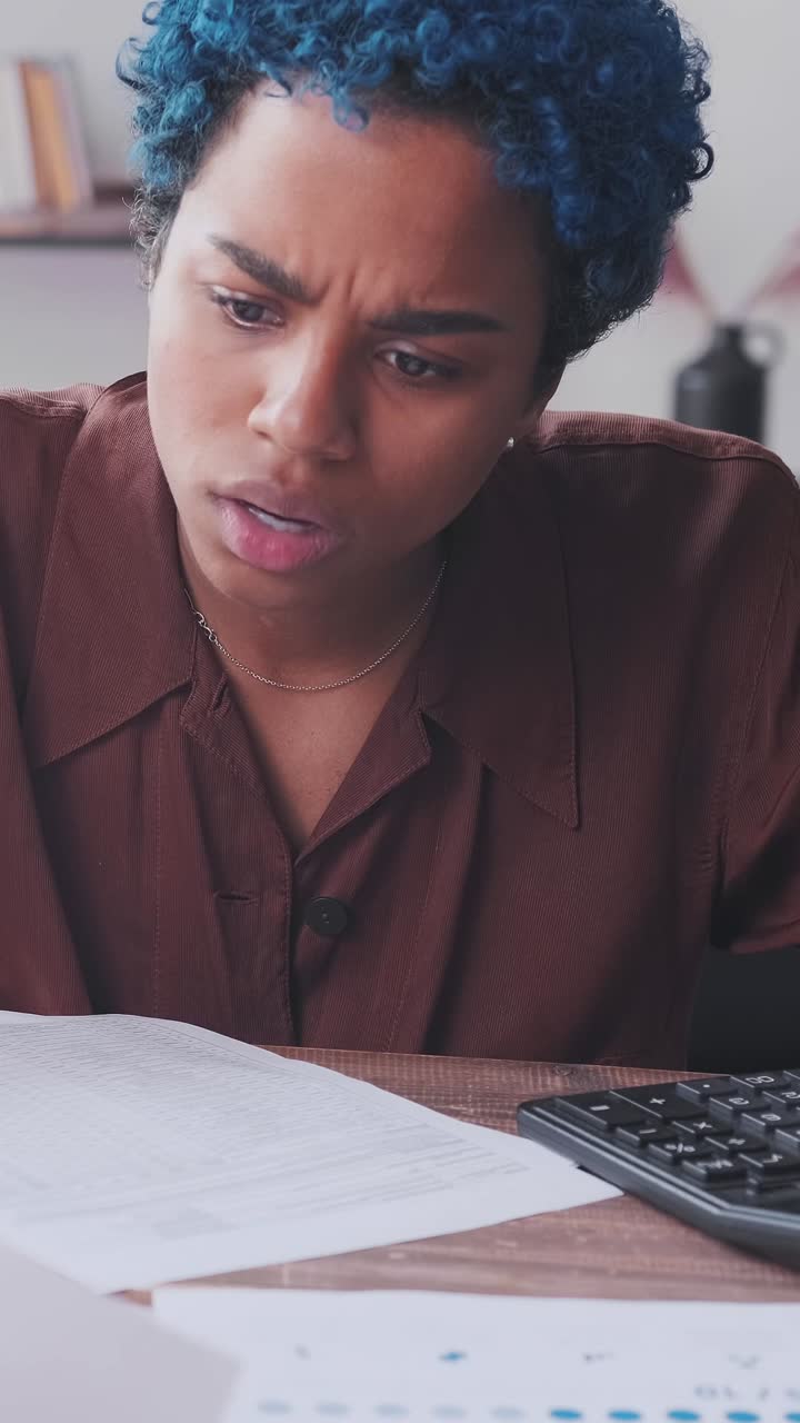 Young african american woman accountant uses calculator for financial audit