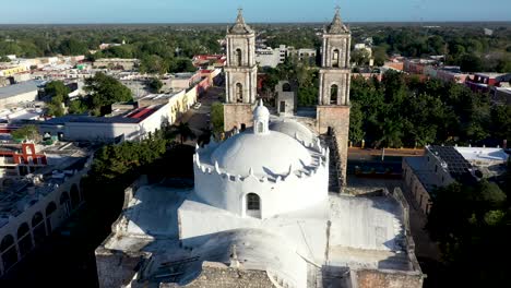 cierre aéreo que se aleja de las torres de la catedral de san gervasio revelando toda la profundidad de la iglesia en valladolid, yucatán, méxico, justo después del amanecer