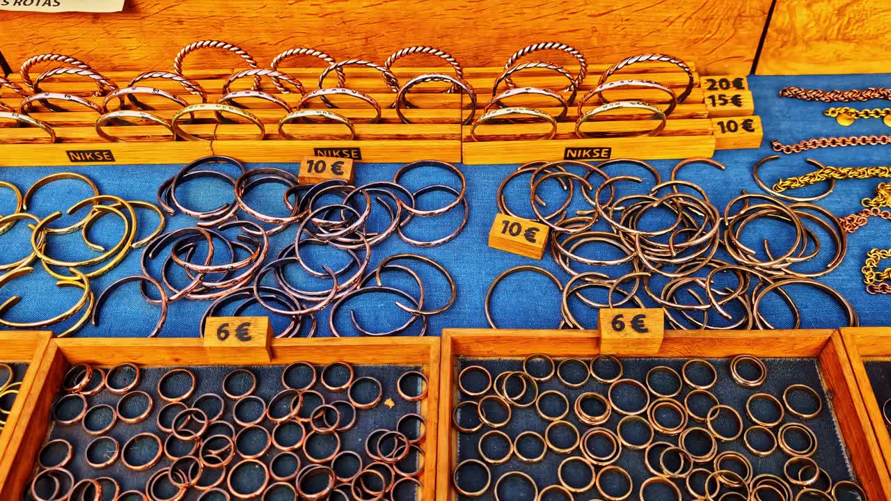 Various Bangles Made Of Bronze Selling At The Market In Riga, Latvia. Tracking Shot