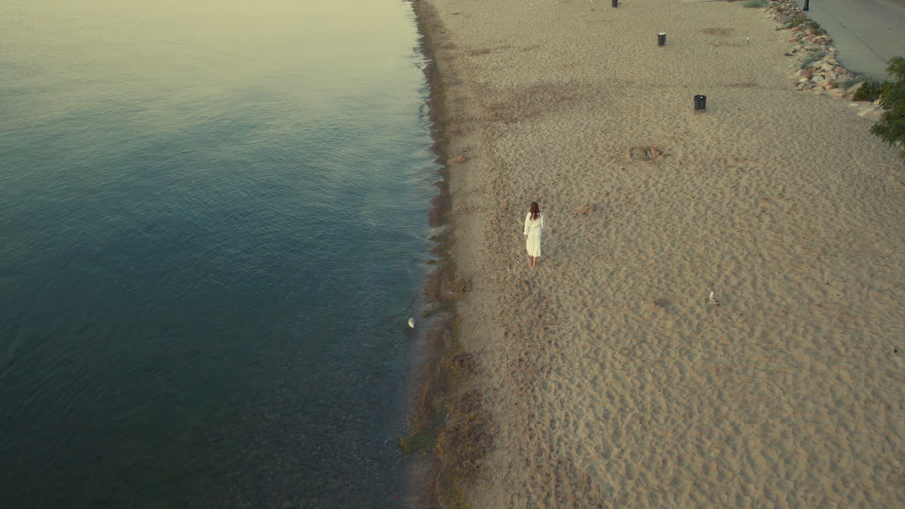 공중 슬로우 모션 여자 는 해가 뜨면 평온 한 바다 에 있는 완벽 한 모래 해변 에서  ⁇ 는 것 을 즐긴다 - 뒤쪽 시야 추적