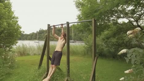 athletic young man reps pullups on outdoor home gym realtime