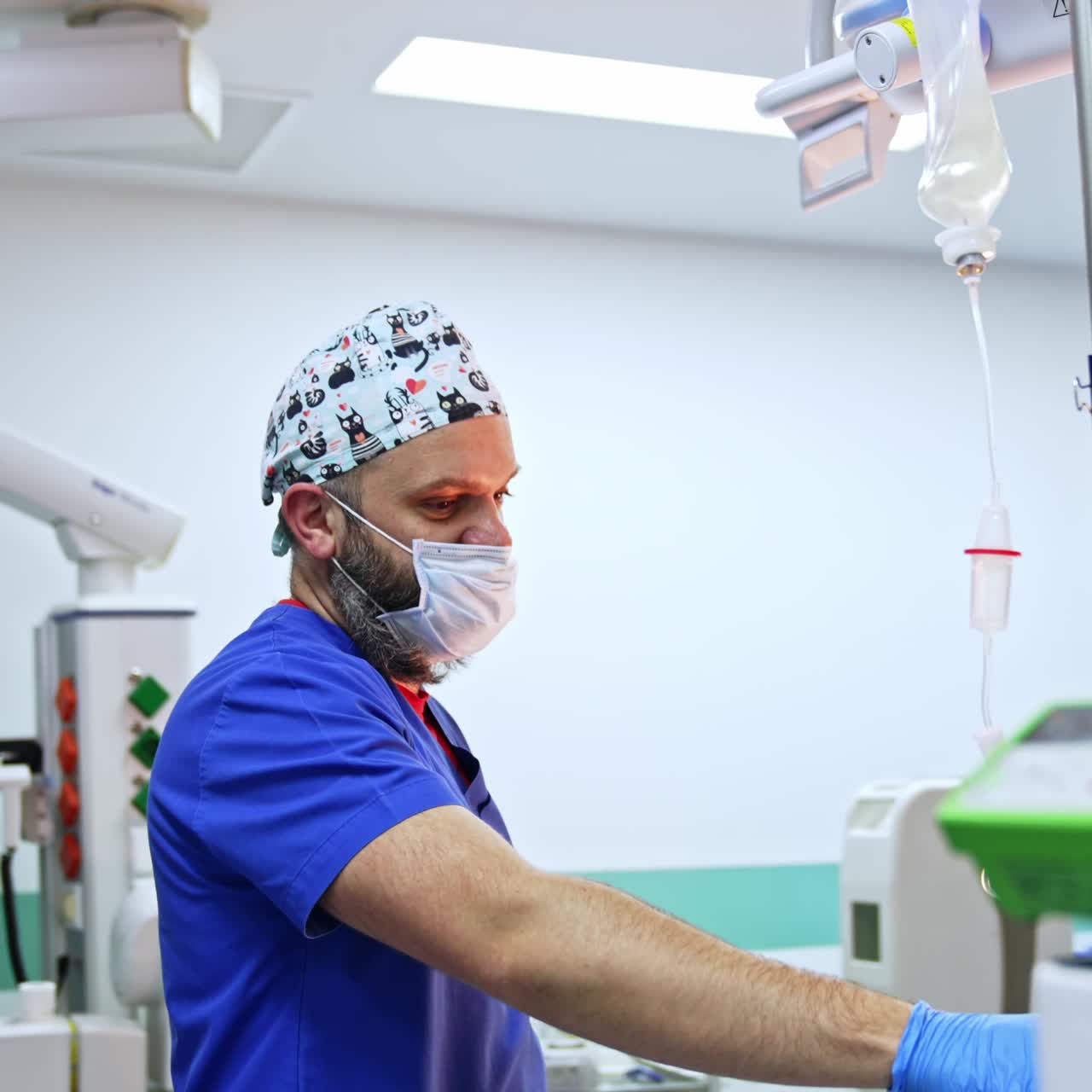 Side view of a male bearded doctor in mask and cap. Anesthesiologist working in the surgery room