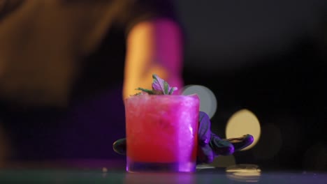 the bartender slides a refreshing red fruit cocktail onto the bar counter