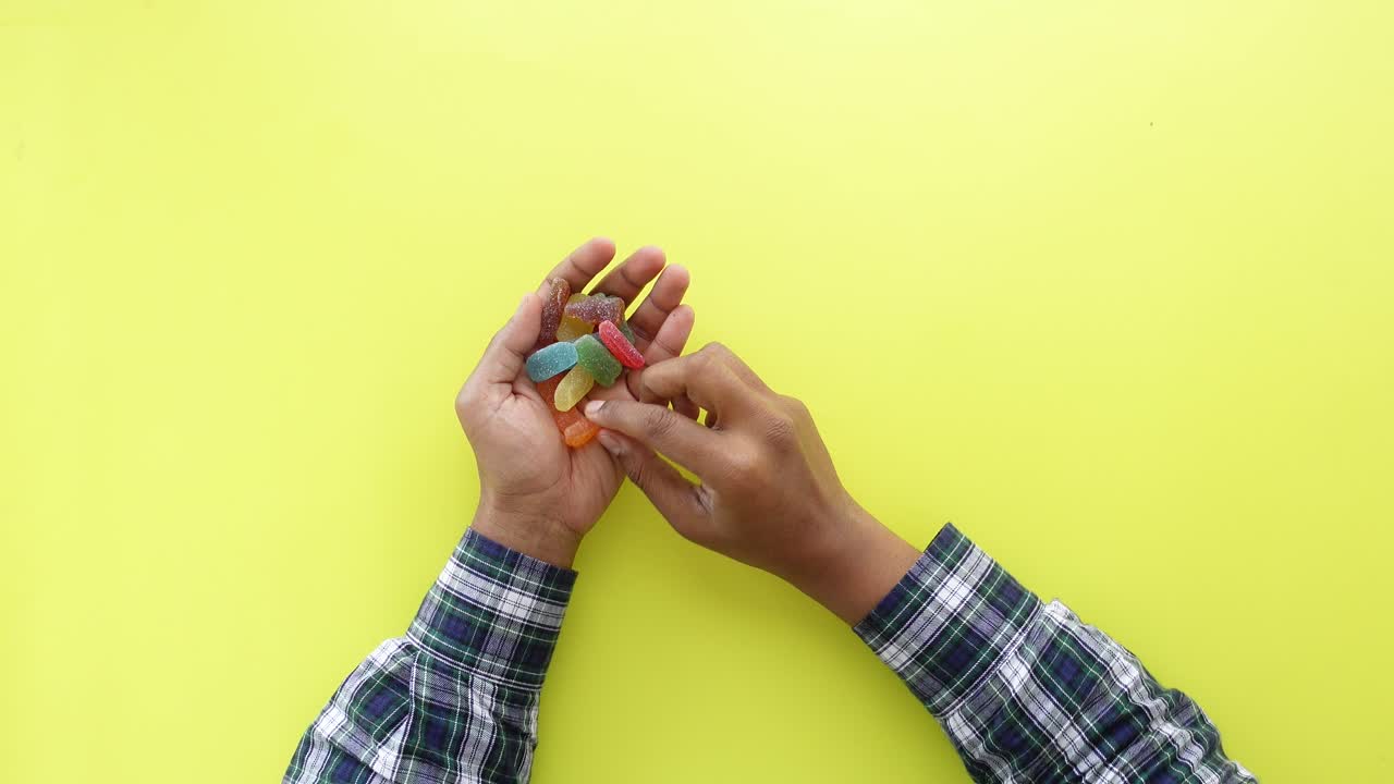 persona con caramelos de jalea de colores