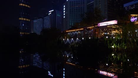 night illuminated guangzhou city downtown megatalls buildings pond reflection panorama 4k