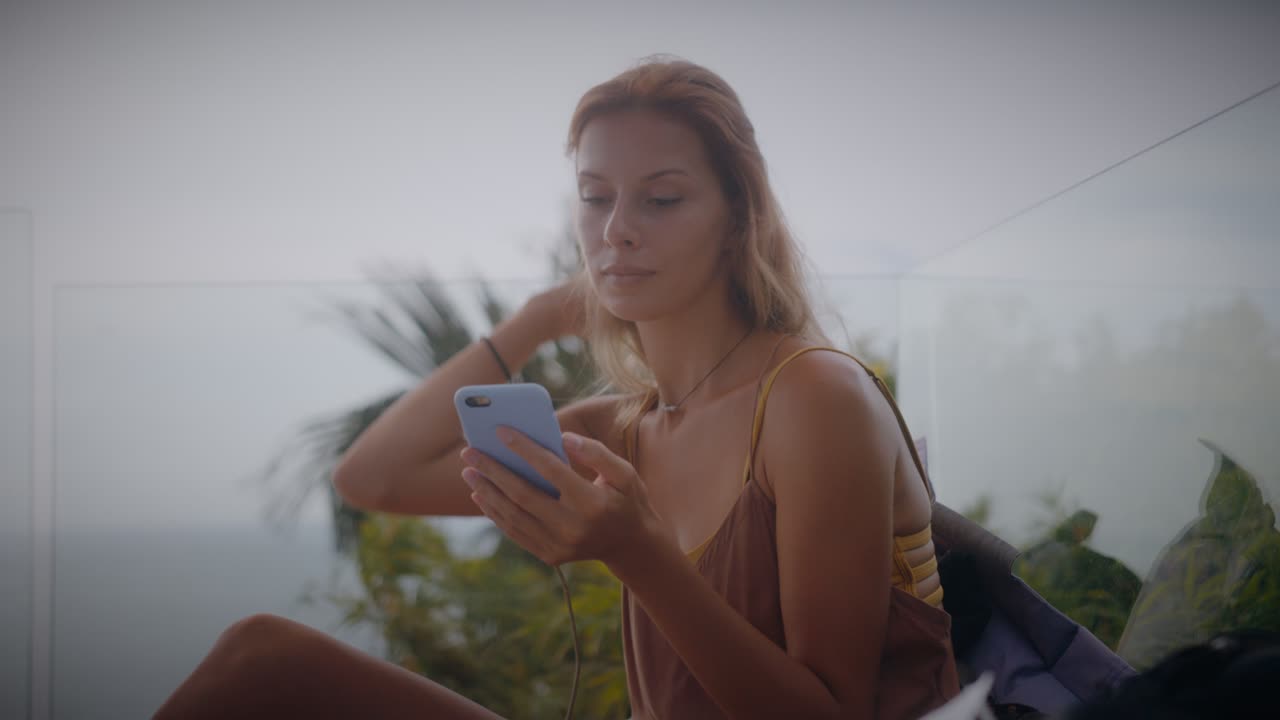 Mulher usando smartphone em uma varanda com vista