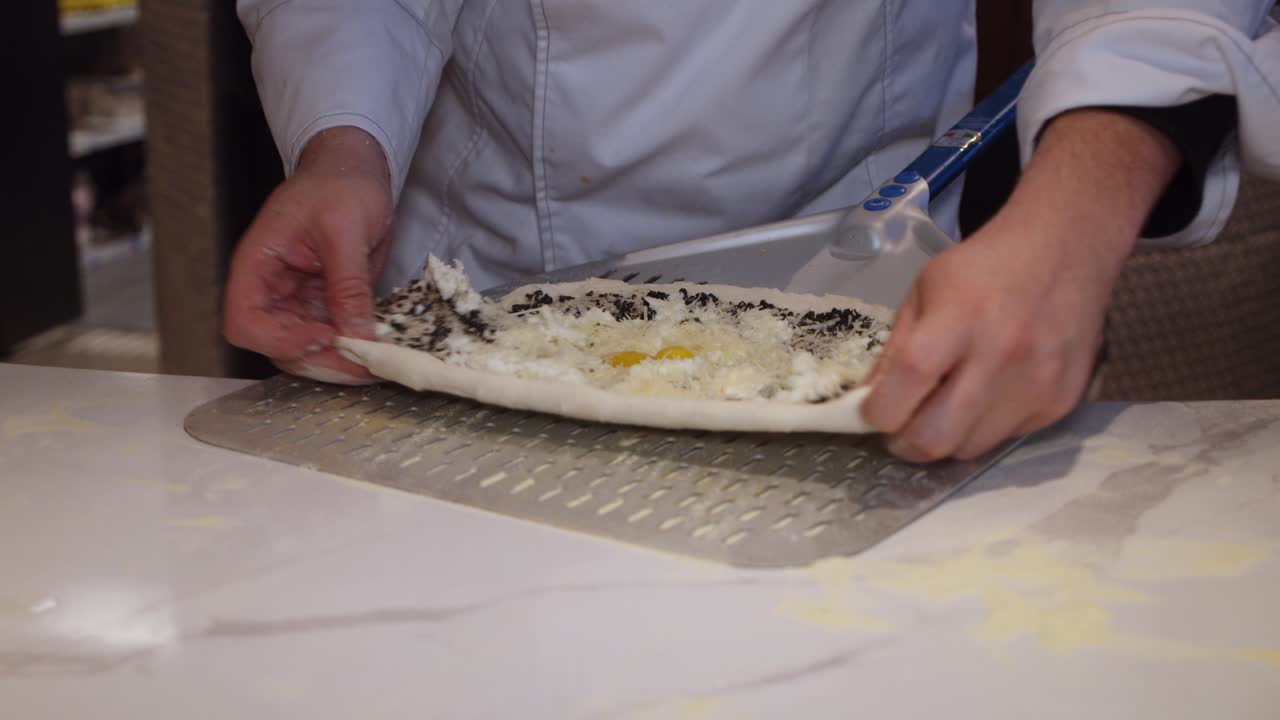 chef pone pizza en una bandeja para hornear