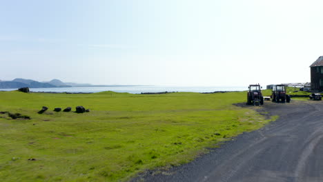 Vista-Aérea-Volando-Hacia-Islandia-Groenlandia.-Vista-De-Drones-Volando-Sobre-El-Campo-De-Islandia-Cerca-De-Una-Casa-De-Campo-Que-Revela-Una-Impresionante-Playa-De-Roca-Negra